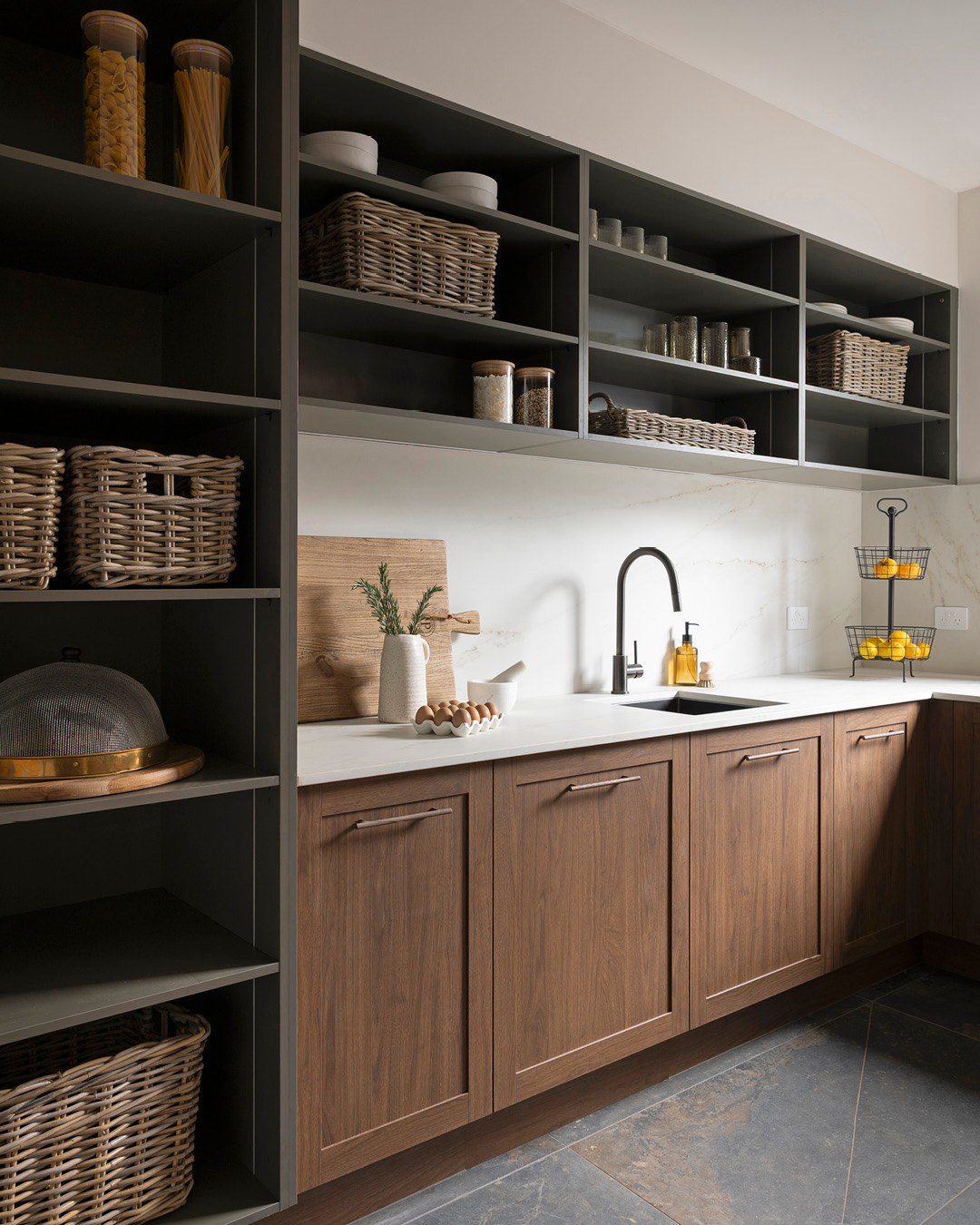 Butlers pantry with open shelves, shaker-style walnut timber-look cabinets and bench space.