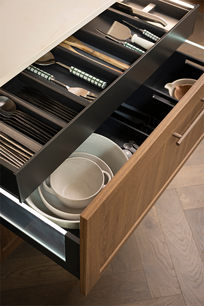 Hettich AvanTech YOU drawers with side illumination and integrated cutlery trays, knife block, and foil compartments, provide practical kitchen storage.