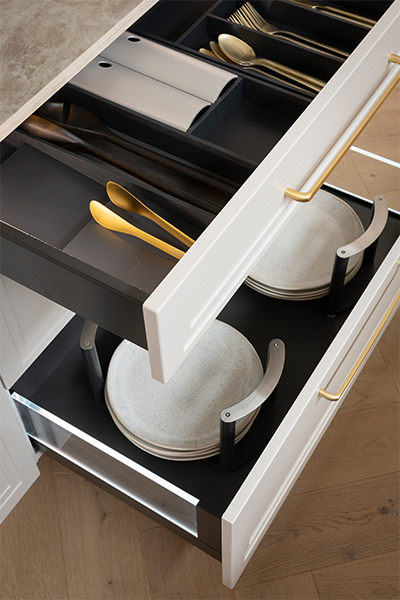 Hettich AvanTech YOU drawers with side illumination, cutlery trays, non-slip mats, and detergent pull-out for organised kitchen storage.