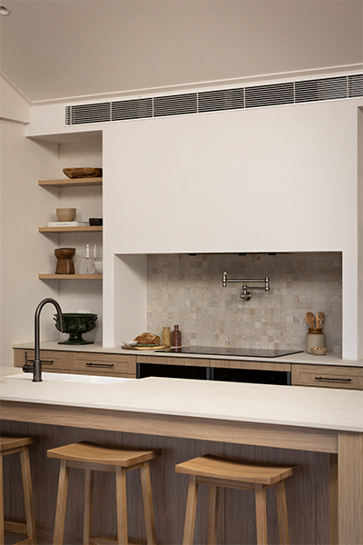 Timeless kitchen with warm wood grain cabinetry, elegant white benchtops, and a farmhouse sink.