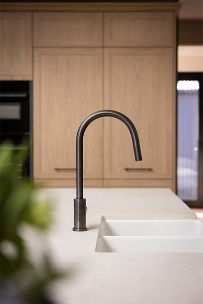 Farmhouse kitchen featuring Sienna Nordic Oak cabinetry, white farmhouse sink, and gunmetal tap.